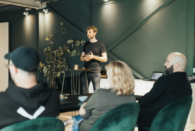 ACCOLTA Business presentation in a modern office setting with a diverse group listening attentively.