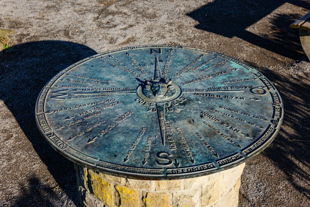 A detailed view of the compass rose direction indicator in Coesfeld, Germany, under bright daylight.