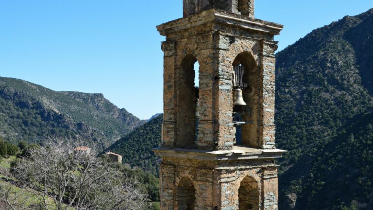 PRUGETTI Rustic bell tower in Asco, Corse, France with scenic mountain backdrop.